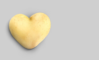 Obraz premium Heart shaped potato on grey background. Banner design with space for text