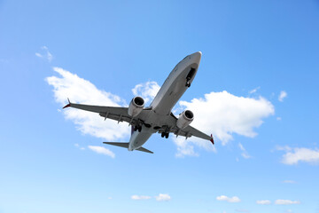 Airplane flying in beautiful blue sky with clouds