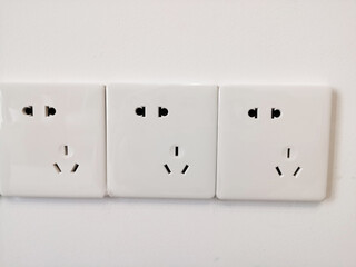 Close-Up of Three Aligned White Electrical Power Sockets