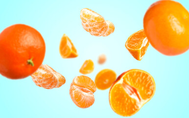Juicy tangerines swirling in air against light blue gradient background