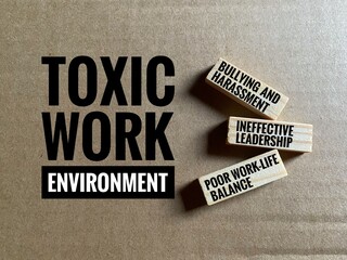 Conceptual photo depicting a toxic work environment, with wooden blocks listing common issues like...