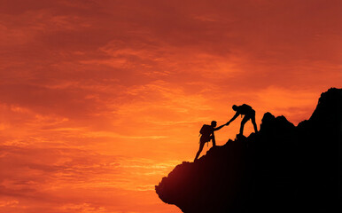 Team of hikers helping each other on a mountain peak – teamwork, leadership, success and business journey concept

