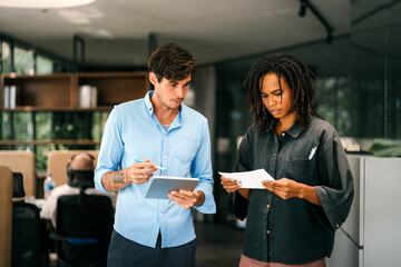 Group of young multi-ethnic startup business team collaborating on project in modern office