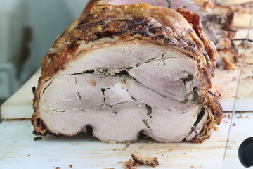 Delicious porchetta resting on cutting board showing its seasoning
