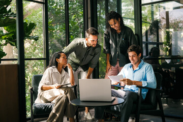 Group of young multi-ethnic startup business team collaborating on project in modern office