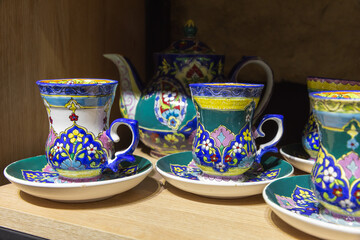 Elegant and Colorful Ceramic Tea Set Displayed on a Wooden Shelf