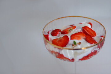 Fresh strawberry dessert with whipped cream in an elegant glass, top view. Sweet and refreshing...
