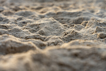 Close-up texture of beach sand mounds at dusk with selective focus, natural surface and detail for backgrounds