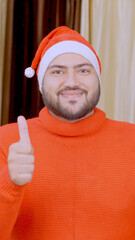Naklejka premium Vertical Photo of Indian Man Showing Thumbs Up with Christmas Tree in background