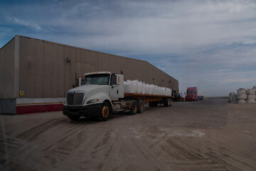 White semi-truck loaded with big bags of salt, parked in front of a salt factory in baja california, mexico, ready for distribution