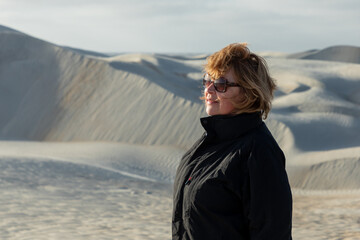 Redhead tourist savoring panoramic white sand dunes stretching across serene desert landscape