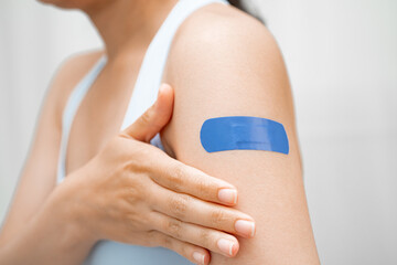 HPV, Human papillomavirus, Asian young woman receiving vaccine with blue bandage.