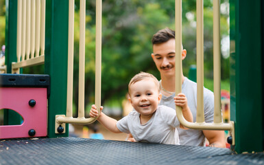 father with child boy on a playground having fun together