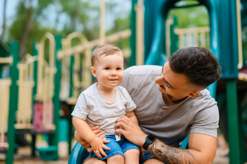 father with child boy is sitting on the slide with it
