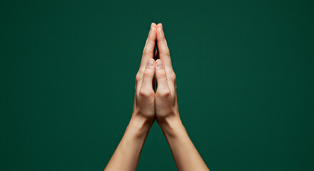 Praying hands against green background