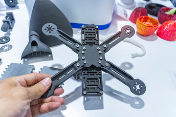 hand holding Drone frame 3d printed by 3D printer. Modern additive technology.
