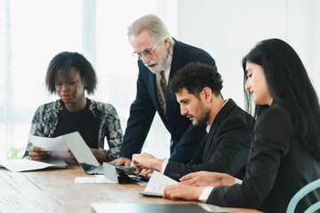 Young Hispanic businessman startup working meeting or brainstorm marketing business plan with senior partner or customer at workplace, professional diverse teamwork employees conference together