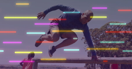 Leaping male hurdler in athletic shirt clearing wooden rail barrier in park, with bars overlay