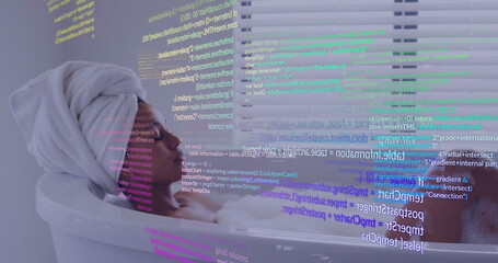 Reclining woman with towel turban displaying vivid code streams across face, in white bathtub