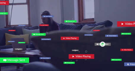 Typing mature woman leaning forward toward laptop in modern living room, with notification overlays