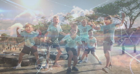 Six kids striking athletic stances in obstacle course area, with worn tires and digital overlay