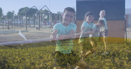 Pulling rope, four boys in teal shirts leaning back in schoolyard grass, with climbing frames