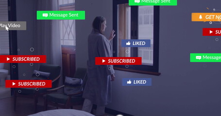 Standing mature female wearing gray coat by wooden window in bedroom, with floating notifications