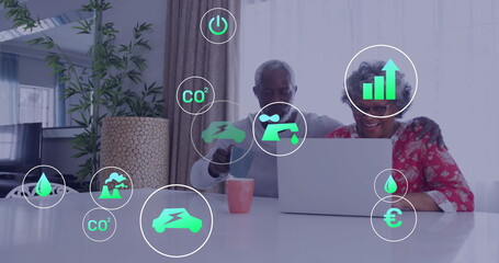 Analyzing senior African American couple using silver laptop in living room, with green icons