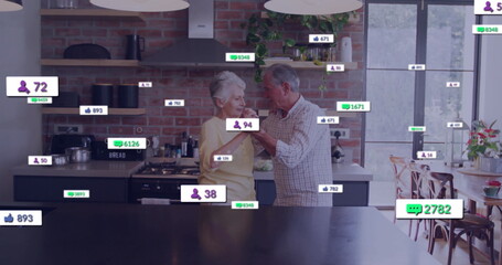 Dancing seniors wearing checked shirt and sweater in home kitchen with dark island, floating icons