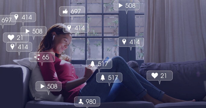 Relaxing woman reclining on cushioned sofa using earbuds, tablet in living room, social media icons