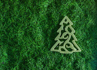 Christmas tree toy with green needles in the background. Decor top view