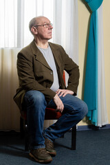 Middle aged man in green jacket beautiful curtain on window