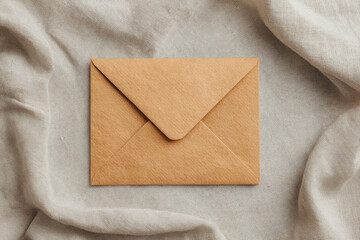Kraft envelope appears simple and natural, resting on linen cloth