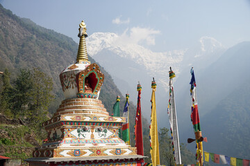 Chhomrong Gumba Stupa decorated with colorful prayer flags in Annapurna Base Camp trek, Nepal.