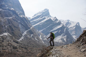 Young asian female hiker carrying mountain backpack and using trekking pole took photos after...