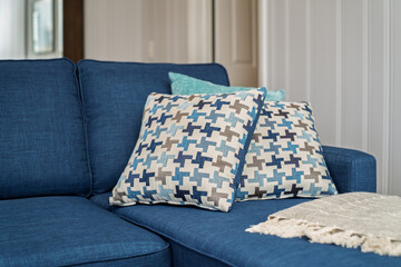 Blue Sofa with Patterned Throw Pillows and Cozy Blanket in Modern Living Room