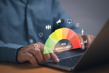 Risk management and data analysis concept, businessman working with computer showing risk assessment of business organization performance to reduce impact of operations with virtual graphics