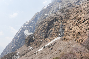Snow-capped Mount Annapurna peaks visible in the morning with ray of light and mist at Annapurna...