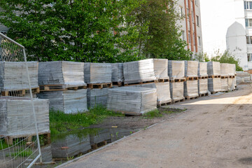 Stacks of paving stone tiles on wooden pallets at construction site