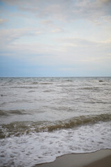 Calm sea under cloudy sky at sunset time