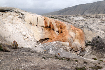 Gray sand mountains in the north of Yellowstone. In the center there are deposits of red color