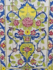 Colorful ceramic tile mural featuring floral patterns and birds in vibrant hues and intricate...