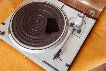 Cleaning a vintage turntable with microfiber cloth for retro music enjoyment