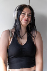 Smiling woman wearing wireless headphones enjoying music indoors