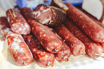Delicious sausages and salami are lying on the table at the market