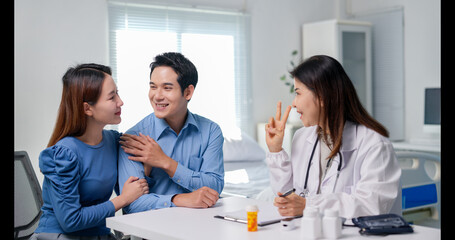 A doctor is talking to a man and a woman in a hospital room