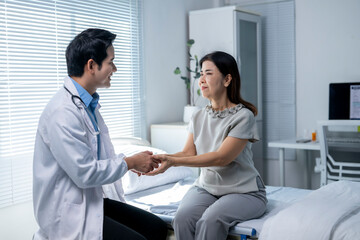 A doctor is shaking hands with a woman in a hospital room