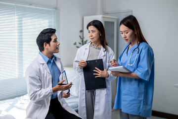 Three doctors are standing in a room, one of them is wearing a blue shirt