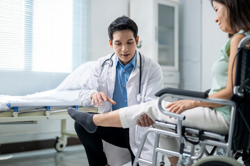A doctor is helping a woman in a wheelchair