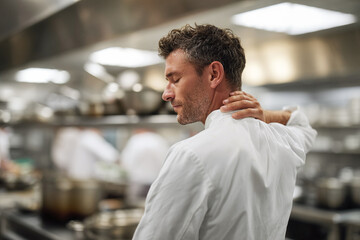 Tired chef in a busy kitchen. Symbolizes stress, burnout, and hard work. Useful for illustrating articles on hospitality, mental health, or career challenges.